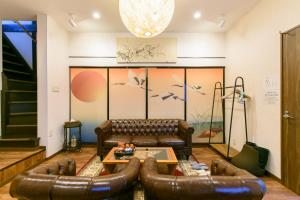 a living room with leather couches and a table at Kyooyado Muromachi in Kyoto