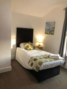 a bedroom with a bed and a lamp and a bed sidx sidx sidx at Trinity Guest House in Hartlepool