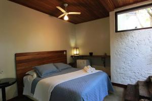 a bedroom with a bed with a ceiling fan at Pousada Santa Vila in Serra do Cipo