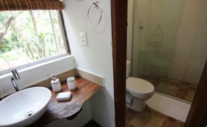 a bathroom with a sink and a toilet and a window at Pousada Santa Vila in Serra do Cipo