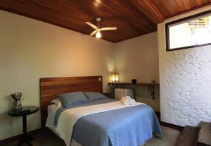 a bedroom with a bed with a ceiling fan at Pousada Santa Vila in Serra do Cipo