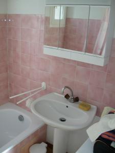 uma casa de banho rosa com um lavatório e uma banheira em DOMAINE DE FONT MOURIER em Gassin