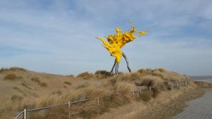 a yellow sculpture on the side of a road at Charmant appartement met frontaal zeezicht in Middelkerke