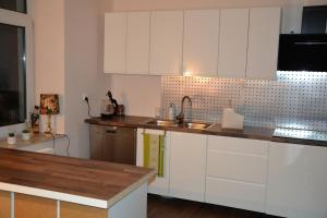 a kitchen with white cabinets and a sink at Noclegi Sulejów in Sulejów