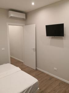 1 dormitorio con 1 cama y TV de pantalla plana en la pared en Pontassieve Guest house Centro Storico Appartamento 20 minuti da Firenze, en Pontassieve