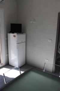 una camera con frigorifero e televisore sopra di "SUPER" a Torre Lapillo a 30 e a 80 mt dalla spiaggia Casa Dario a Torre Lapillo