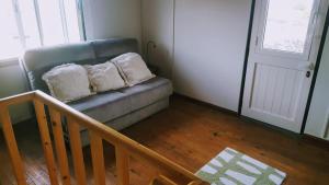 - un canapé avec deux oreillers dans le salon dans l'établissement Quinta do Lago, à São Roque do Pico
