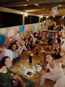 een groep mensen die rond een tafel zitten bij Freesoul Hostel in Palomino