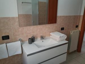 W łazience znajduje się biała umywalka i lustro. w obiekcie Guest House Brezza Marina w mieście Fiumicino