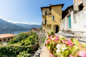 a house on a hill with flowers in front of it at Albergo Diffuso Ca' Spiga in Laglio