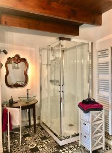 a glass shower in a bathroom with a table at La Ferme Wessière in Oye-Plage