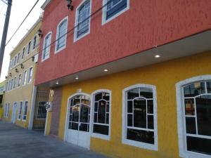 żółto-czerwony budynek z białymi oknami w obiekcie Hotel San Luis w mieście San Luis Potosí
