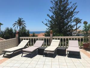 un grupo de sillas en un patio con una valla en Marbella Villa on the beach, en Marbella