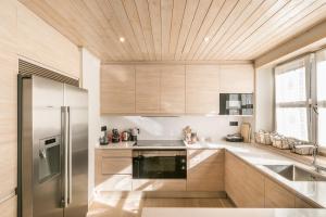 a kitchen with wooden cabinets and a stainless steel refrigerator at Casa Daria by Totiaran in Baqueira-Beret