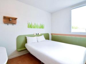Postel nebo postele na pokoji v ubytování Ibis Budget Grenoble Sud Seyssins