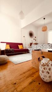 ein Wohnzimmer mit einem Sofa und Holzböden in der Unterkunft Espinho Guesthouse - Garden House in Espinho