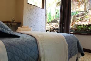 a bedroom with a bed and a window with a view at Pousada Santa Vila in Serra do Cipo