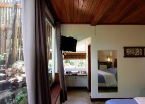 a bedroom with a bed and a television on a wall at Pousada Santa Vila in Serra do Cipo +37 photos