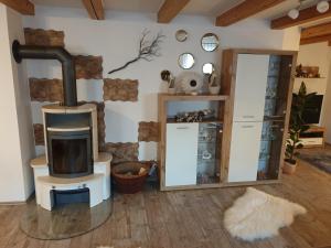 uma sala de estar com um fogão a lenha e um espelho em Martin´s Ferienwohnung em Furth im Wald