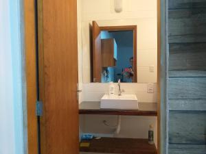 een badkamer met een wastafel en een spiegel bij Lofyt em Paraty in Paraty +7 foto's