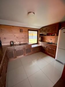 Strizhevka的住宿－Дом для отдыха Lake House，厨房配有木制橱柜和冰箱。