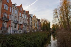 una fila de casas junto a un río con edificios en VEGAN, PLANT BASED b&b central Bruges, en Brujas