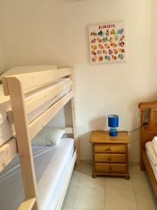 a bedroom with a bunk bed and a night stand at Villa Cala Blanca in Alcossebre
