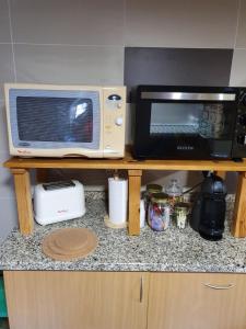 um balcão de cozinha com um micro-ondas e uma torradeira. em Olinda Home em Casas Figueiras