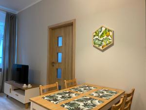 jadalnia ze stołem i telewizorem w obiekcie Apartament URBAN JUNGLE! w Poznaniu