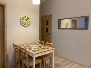 stół jadalny z krzesłami i lustrem w obiekcie Apartament URBAN JUNGLE! w Poznaniu +8 zdjęć
