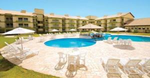 un complejo con piscina, sillas y un edificio en Apartamento/Flat - Condominio Village - Aldeia das Águas Park Resort., en Barra do Piraí