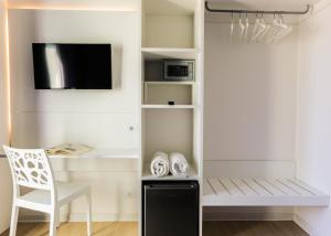 Habitación con escritorio, TV y silla. en San Marco, en Marotta