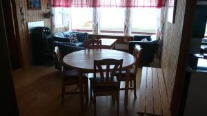uma sala de jantar com uma mesa de madeira e cadeiras em Gemlufall guesthouse em Þingeyri