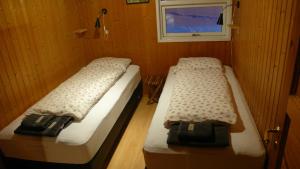 two beds in a small room with a window at Gemlufall guesthouse in Þingeyri