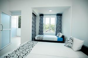 una camera da letto con un letto e una finestra di RoaBaa Guesthouse a Batticaloa