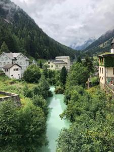 un fiume in una città con edifici e alberi di Alpine Haus a Göschenen