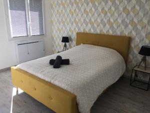 una camera da letto con un letto con un orsacchiotto sopra di MONTALIEU SEJOUR Rez de jardin Les jonquilles - 1 à 4 PERS - PROX CNPE BUGEY - VALLEE BLEU - VIA RHONA a Montalieu-Vercieu