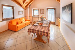a living room with a table and a couch at Appartamenti Casavacanzepejo in Cogolo