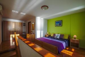 sypialnia z łóżkiem i zieloną ścianą w obiekcie Art House w mieście Stara Baška