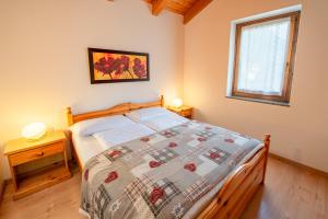 een slaapkamer met een bed met een quilt bij Appartamenti Casavacanzepejo in Cogolo