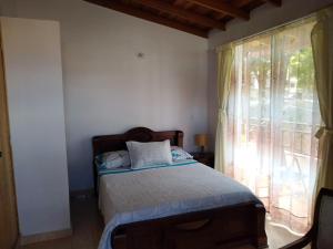 a bedroom with a bed and a window at Mayorca Homestay in Medellín