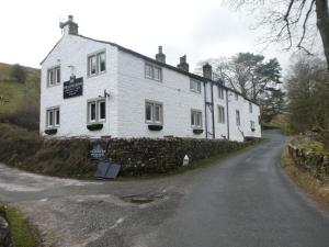 ein weißes Haus am Straßenrand in der Unterkunft The George Inn in Skipton