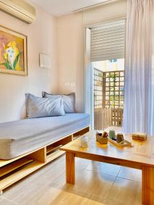 Schlafzimmer mit einem Bett, einem Tisch und einem Fenster in der Unterkunft Jardin de bougainvillier in Sfax