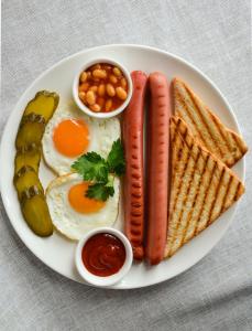 a plate of breakfast food with eggs sausage bread and beans at HOTEL APOLLON in Samarkand
