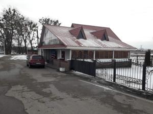 ein Haus mit einem Auto auf einem Parkplatz in der Unterkunft Отель Виктория in Berezyna