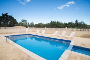 a swimming pool with lounge chairs and a swimming pool at CASA EUGENIO Cala Saona in Cala Saona