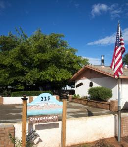 a sign in front of a building with an american flag at Canyon Colors Bed and Breakfast in Page