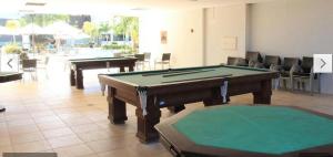 a pool table in a room with two tables at Flats - Veredas do Rio Quente in Rio Quente