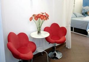 ナポリにあるChiaia Street Holidayの赤い椅子2脚、花瓶テーブル