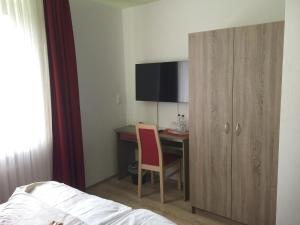 a bedroom with a desk and a bed and a cabinet at Central Hotel in Troisdorf